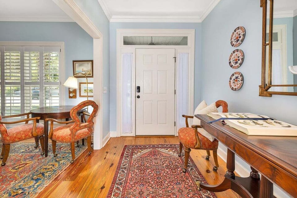 Entryway with wood floors, blue walls, and antique desk