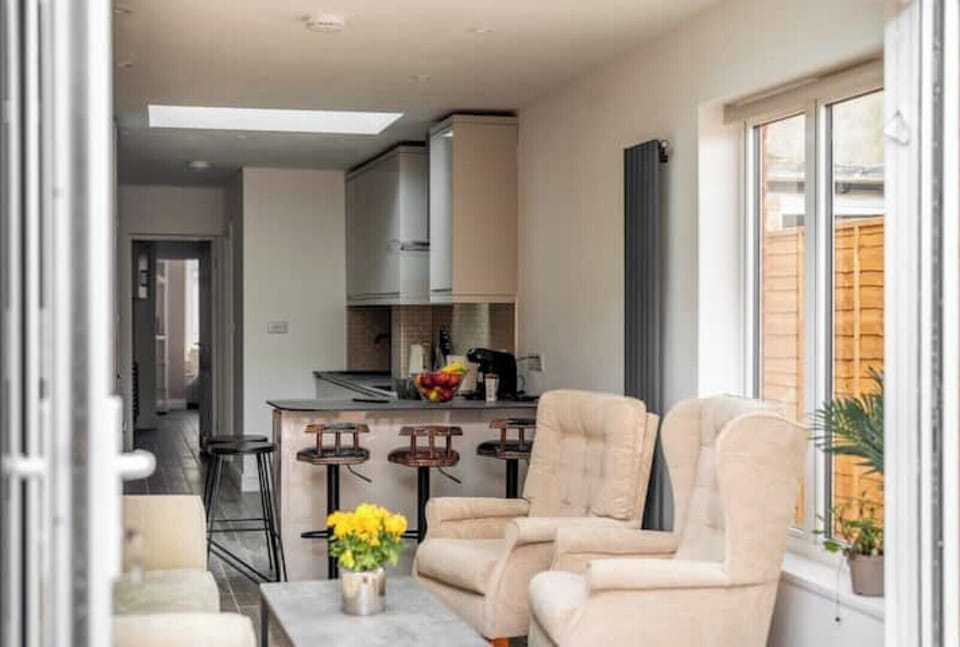 Living room with sofa bed, table, 2 armchairs and Smart TV.