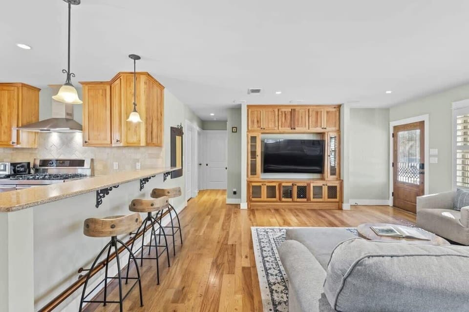 Living room and bar stools leading to two bedrooms down the hall.