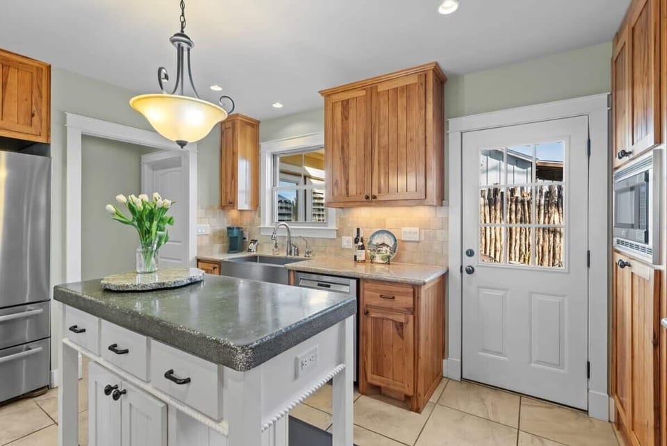 Kitchen island and farm house sink. Access to backyard patio.