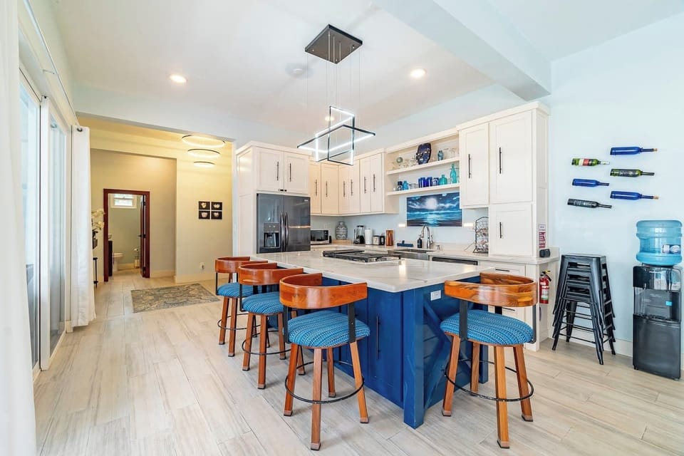 Fully equipped gourmet kitchen with breakfast bar, stainless steel appliances, and vibrant coastal décor on Ambergris Caye