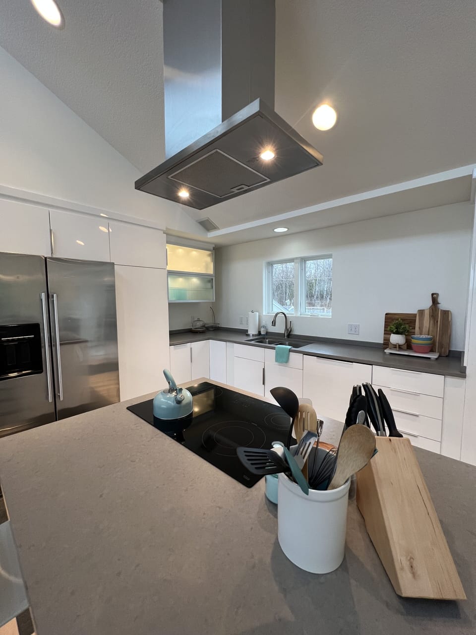 Kitchen island seats 5 and includes cooktop.