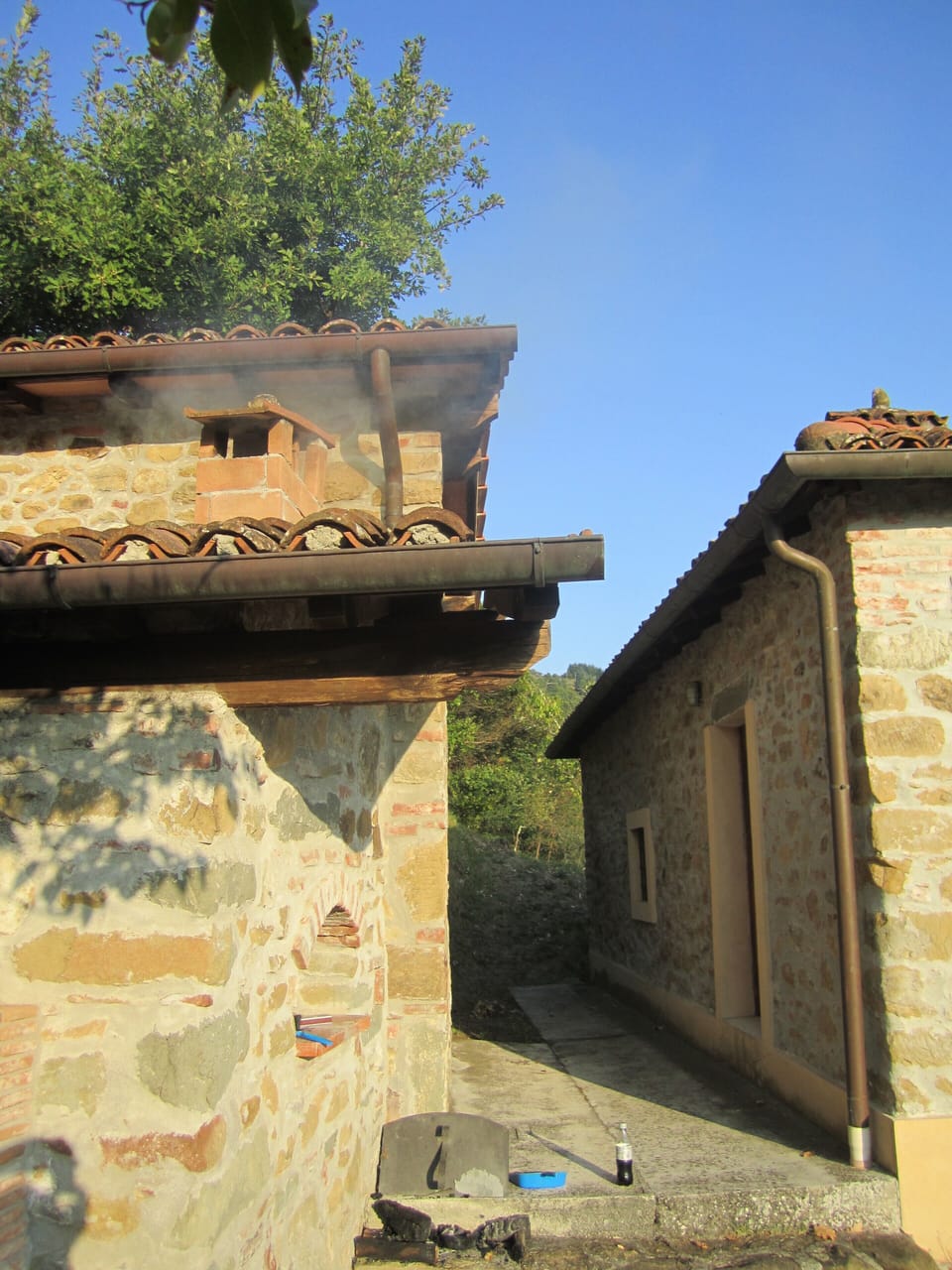 The exterior of the north side with smoke coming from the brick oven.
