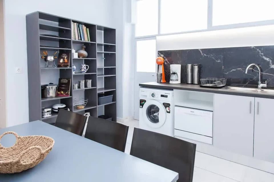 Kitchen with washing machine and  adjacent balcony with clothes line 