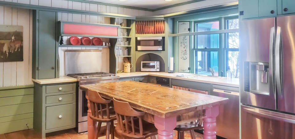 Kitchen with center island seating and bright window views.