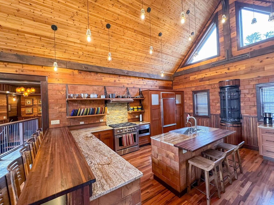 A chef's delight including a six burner gas stove and electric convection oven as well as exhaust hood.   The microwave is tucked under the counter and built into the cabinet to net additional counter top space. 