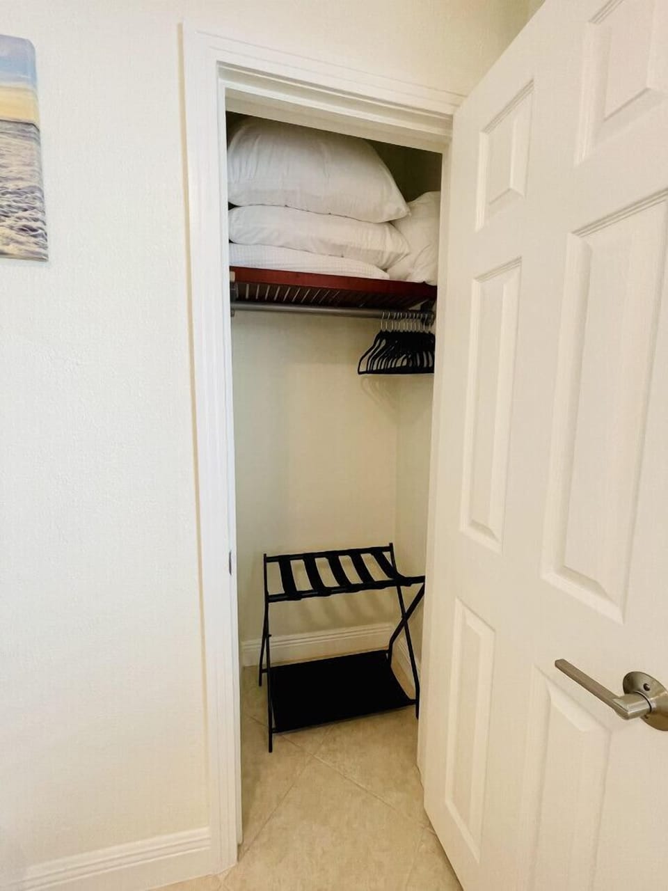 Bedroom 3 closet with extra blankets, pillows, hangers, and luggage rack