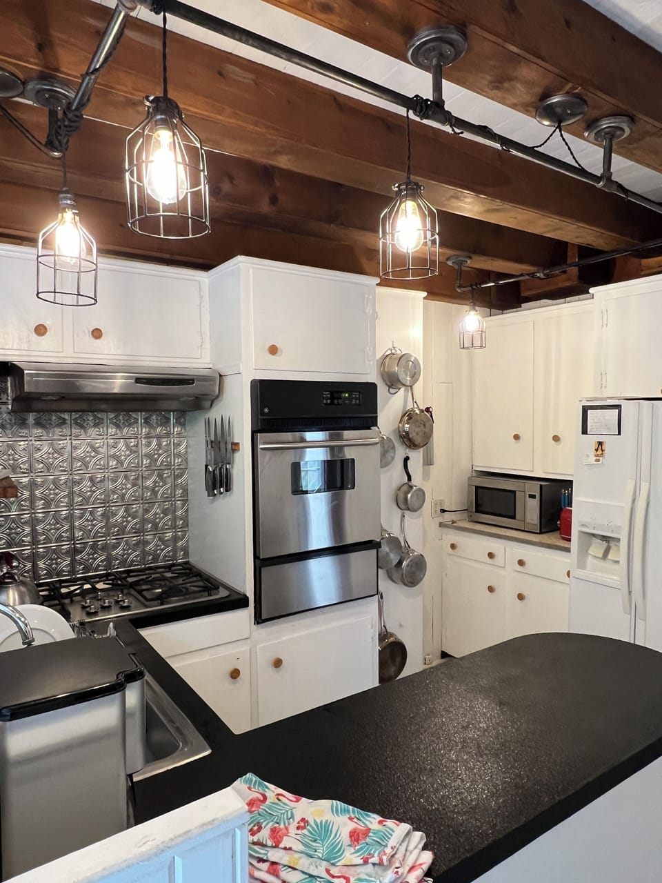 Full kitchen with microwave, stove, oven, coffee maker, toaster, and utensils