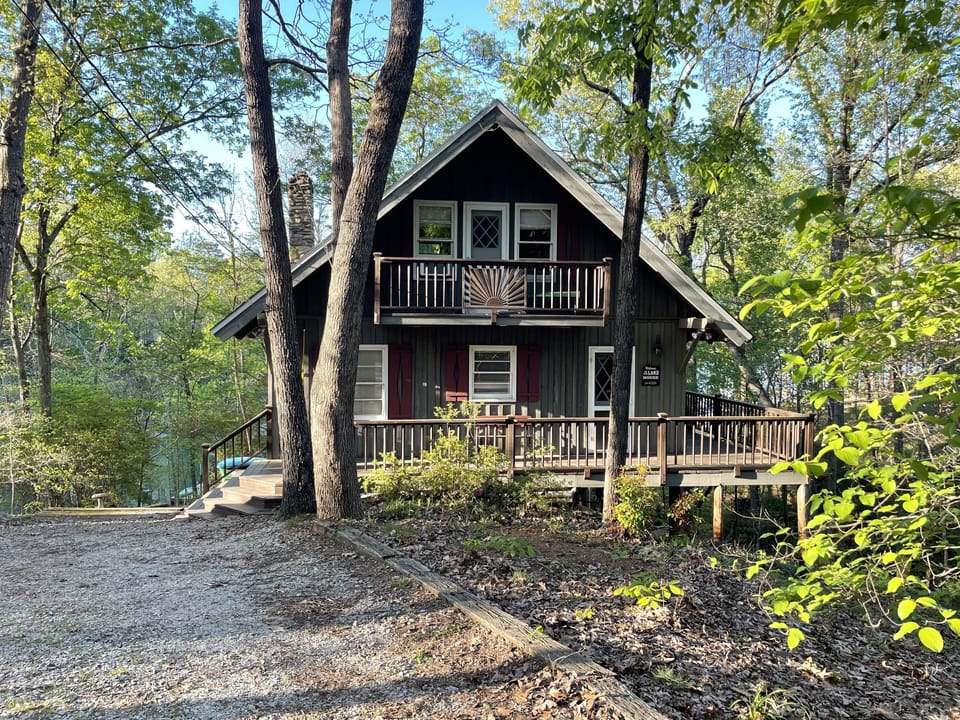 Cozy Cabin with a lower wrap-around porch and two upper porches off bedrooms.