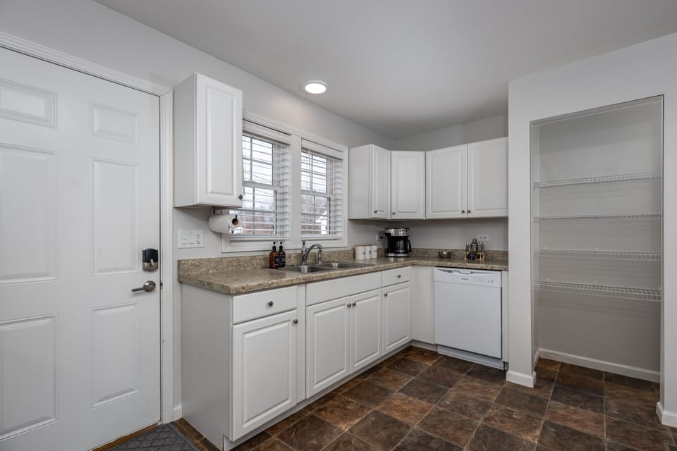 Kitchen has a dish washing machine and a machine brewer & French press.