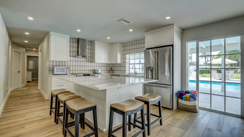 As seen in the picture, the kitchen comes stocked with a microwave, toaster, dishwasher, double oven, and refrigerator. It also offers a large island to eat at.