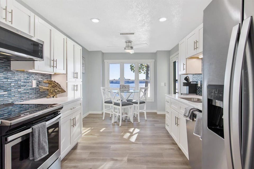 The updated kitchen has a bar height table seating 4 with an amazing lake view.