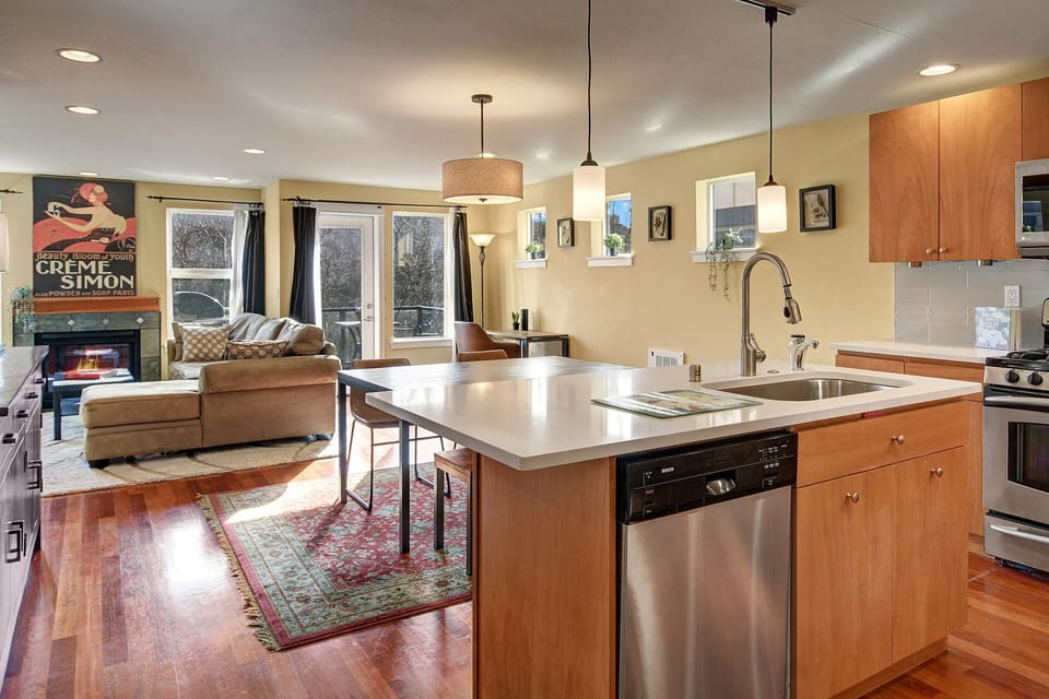 Main level features a refreshed kitchen, dining area, living room, desk and deck