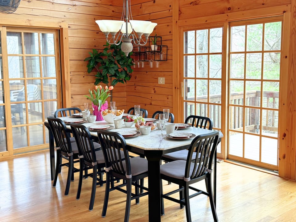 The marble-top dining table is comfortably seating 8. Extra chairs available to sit up to 10. Doors open to the deck and to the 3-season room.