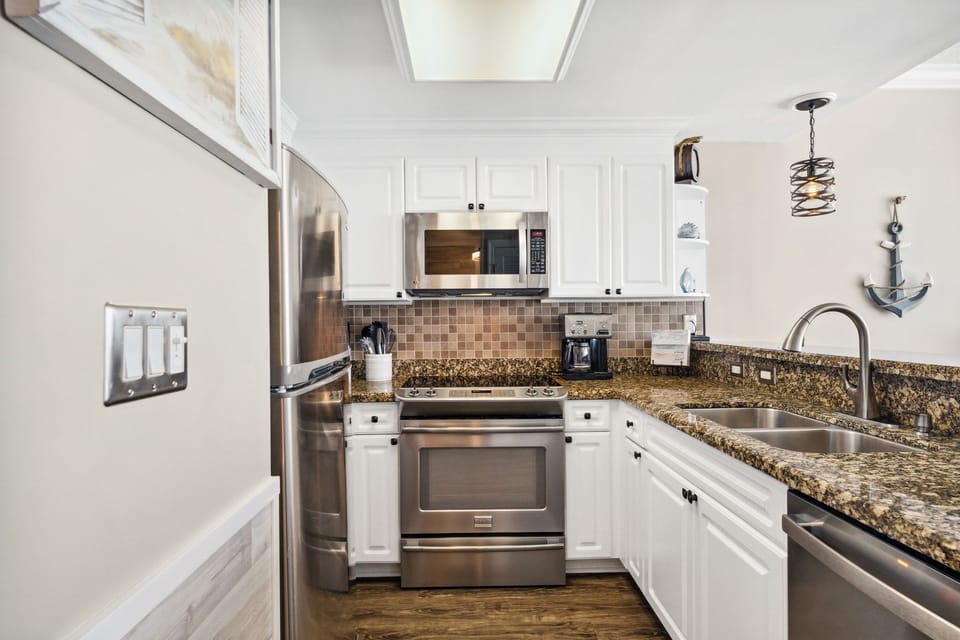 The fully equipped kitchen features granite countertops and stainless-steel appliances.