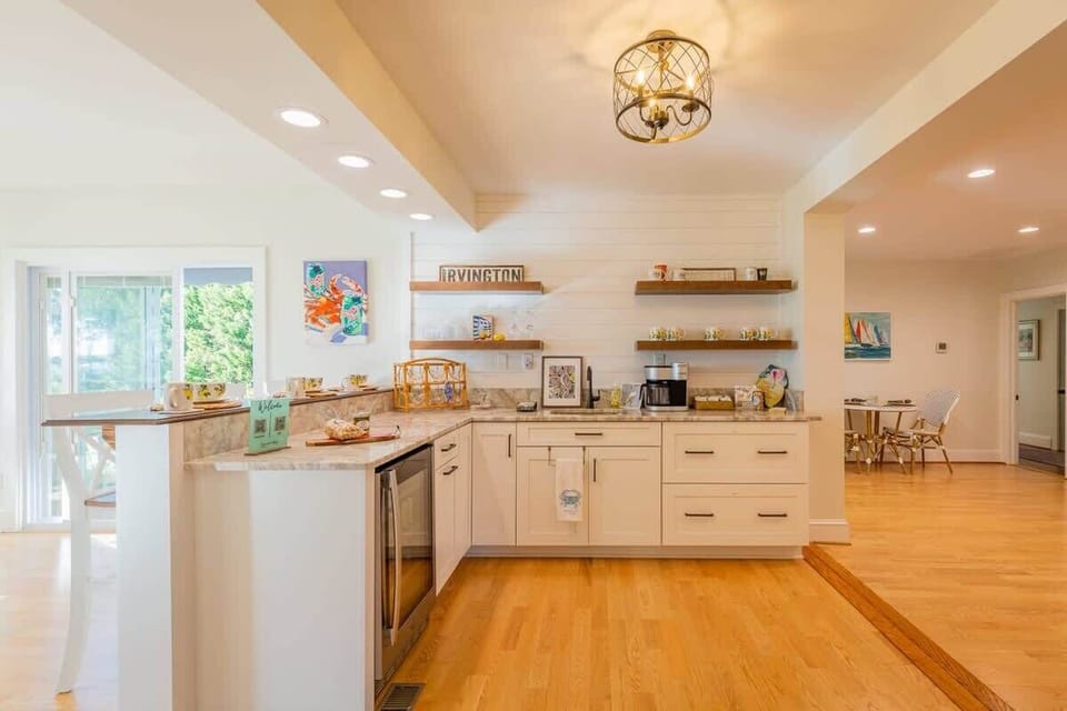 Bright and open kitchen overlooks dining and living space; wine fridge, open shelving