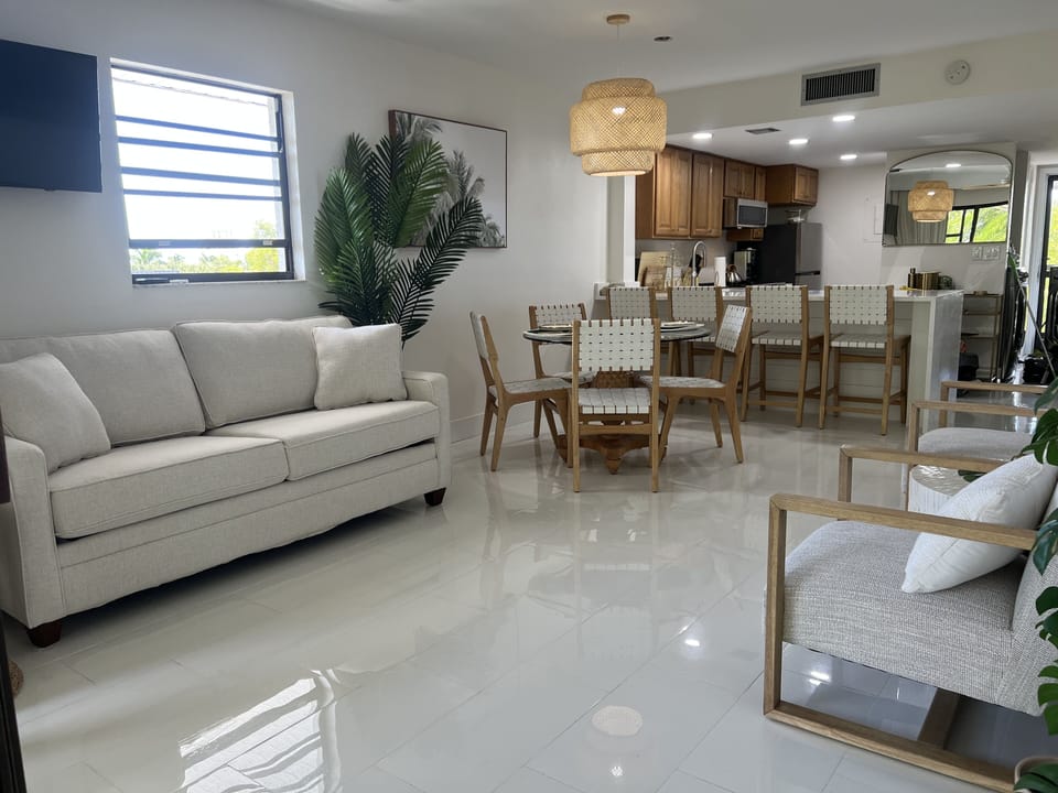 Open floor plan monochromatic color scheme white with splashes of wood and metal