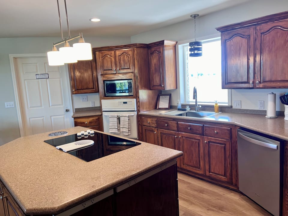 The kitchen has a dishwasher, elective stove, oven, microwave, and refrigerator.