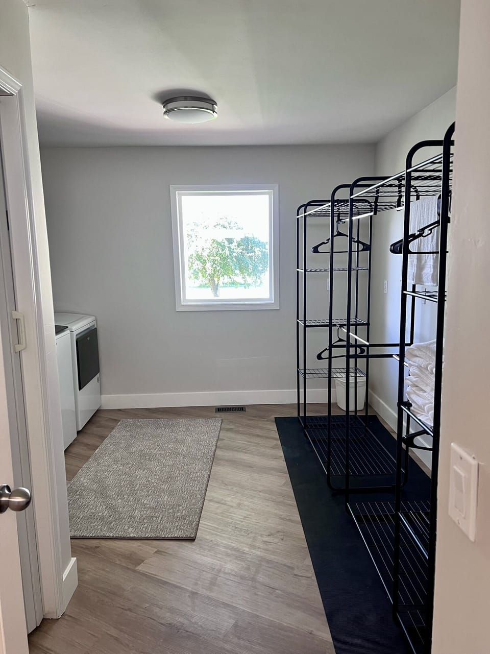 Laundry room with two drying racks for swimsuits and towels in the summer.