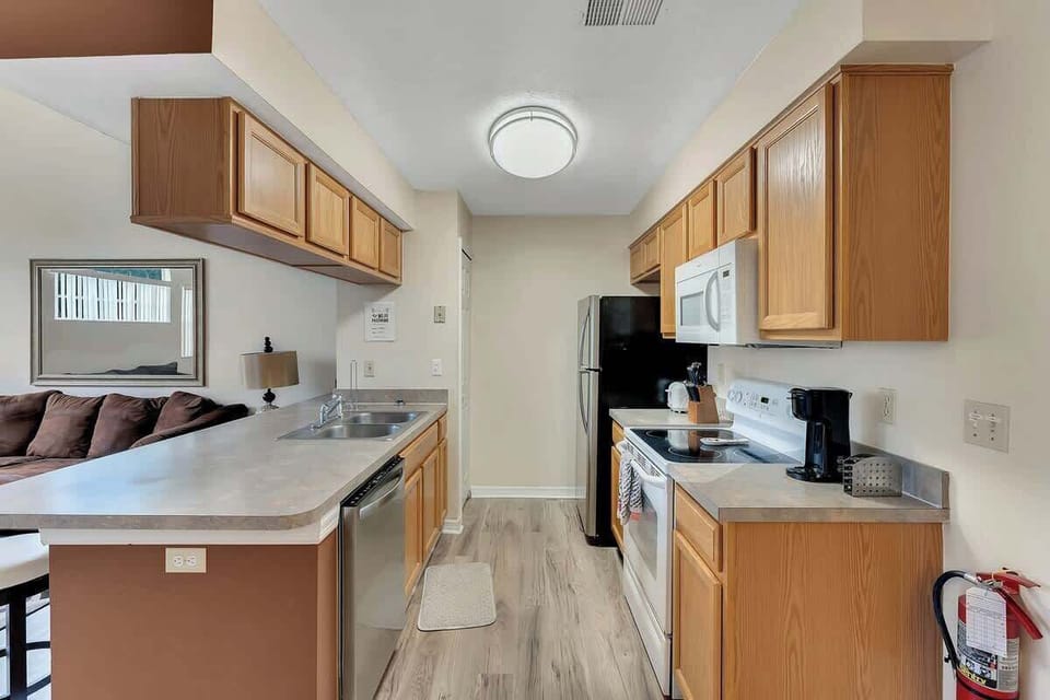 Functional kitchen with ample wooden cabinetry and modern appliances.