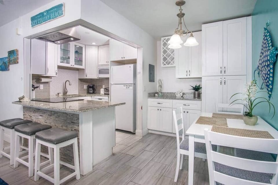 The kitchen is open concept and has granite countertops and tons of dishes, pots, pans etc