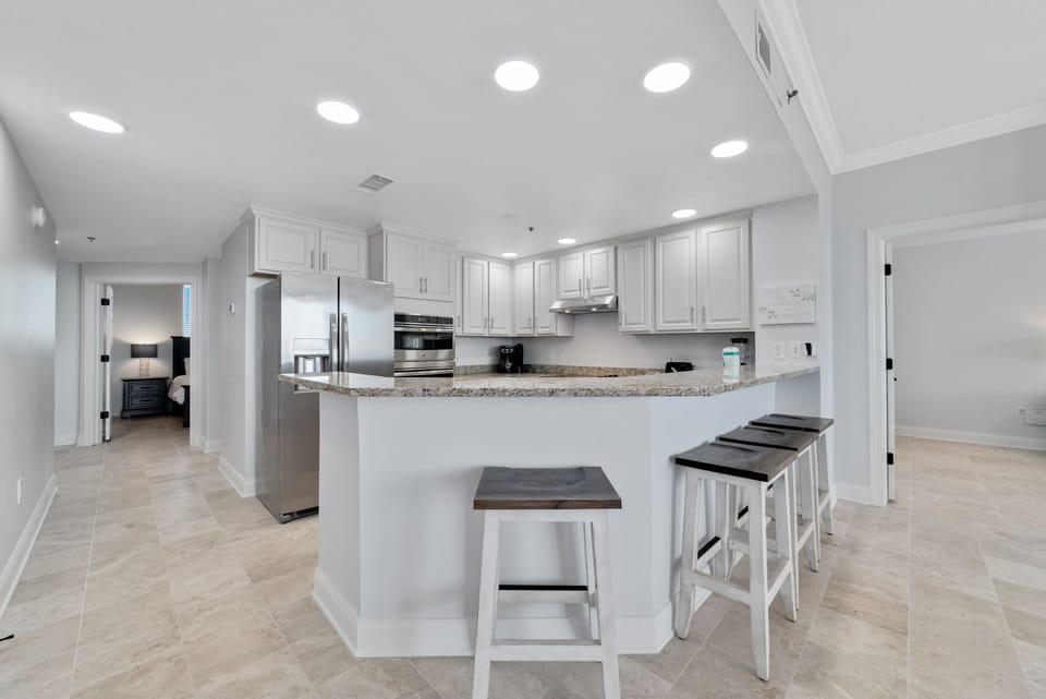 This spacious kitchen bar with seating for four is the perfect spot for casual meals, morning coffee, or gathering with friends. It's the ideal space to socialize while keeping the chef company.