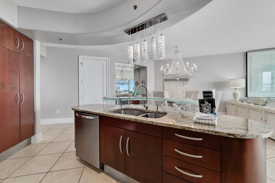 This gourmet kitchen, featuring stainless steel appliances and granite countertops, seamlessly flows into the spacious living area, perfect for entertaining and enjoying breathtaking views.