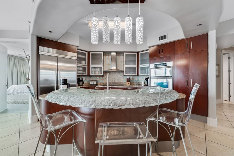Exquisite details abound in this high-end kitchen, from the frosted glass cabinetry to the professional-grade appliances. Experience luxury in every culinary creation.