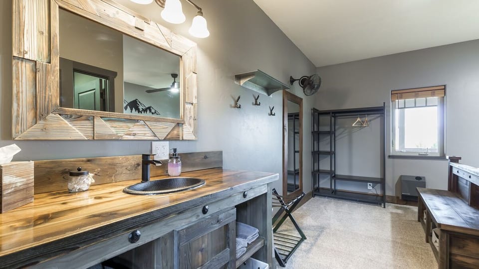 Enjoy our rustic ambiance featuring custom-made, expertly crafted oversized vanities. This uniquely designed furniture offers ample storage space, providing a convenient and stylish solution to store all your travel essentials. (Room 3)