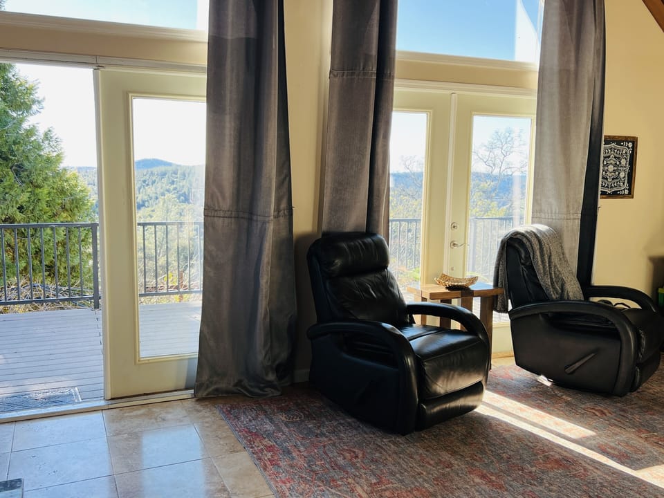 Living room opens to deck, windows with epic views