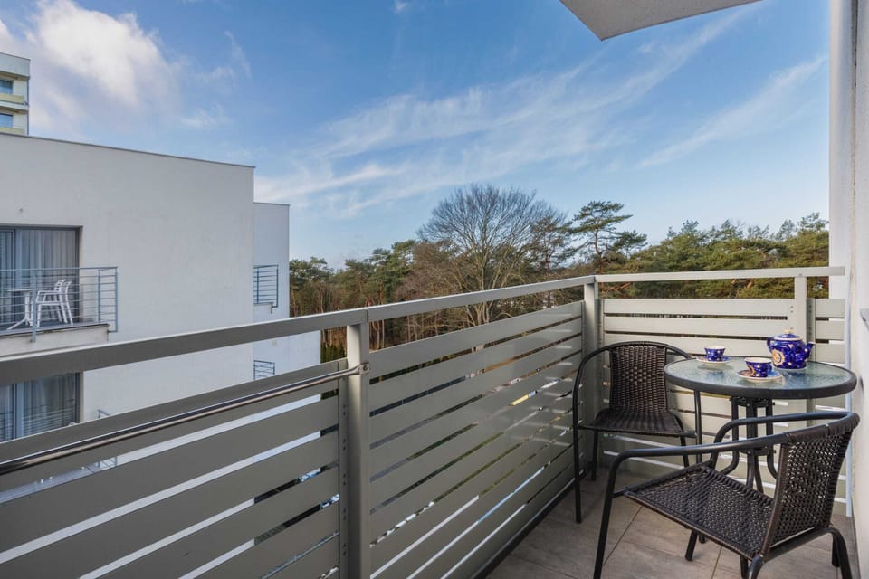 A balcony area with seating, offering a peaceful view of the surrounding greenery.
