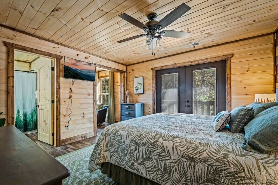 The bedroom includes dressers for storage, an attached bathroom, Smart TV, and separate seating area.