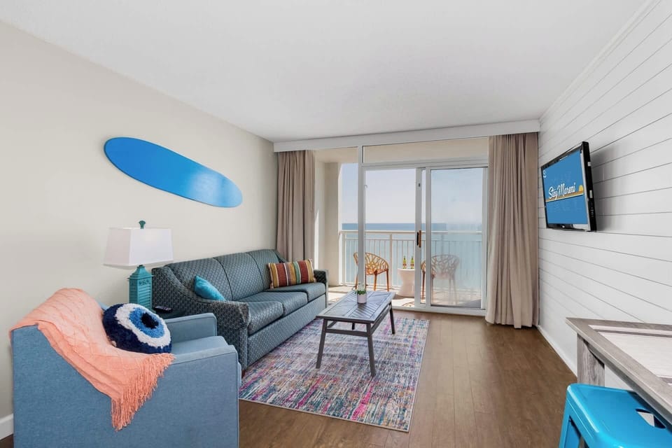 Bright, colorful, and full of charm, this cozy living area is perfect for relaxing after a day at the beach. Enjoy the ocean view from the balcony, cheerful decor, and comfortable seating that makes your stay as inviting as it is memorable.