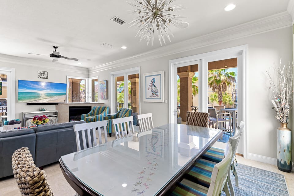 Gather around your elegant dining table while ocean breezes flow through French doors. The stunning chandelier and fireplace create perfect ambiance for meals.