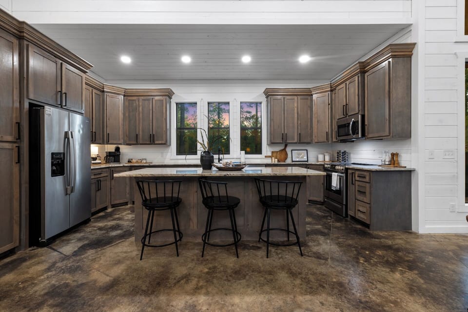 Chat, cook, connect & cherish stunning forest views from the floor the ceiling windows showcasing nature's beauty while you're prepping dinner from the kitchen island with 3 additonal dining seats.