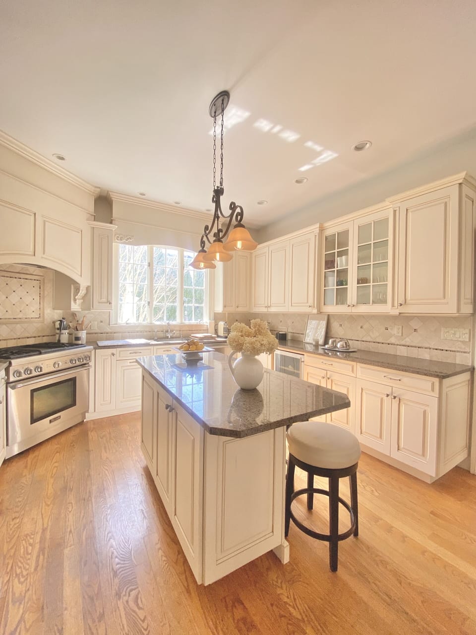 Chefs kitchen with WOLF gas range, island bench, dishwasher, wine fridge.