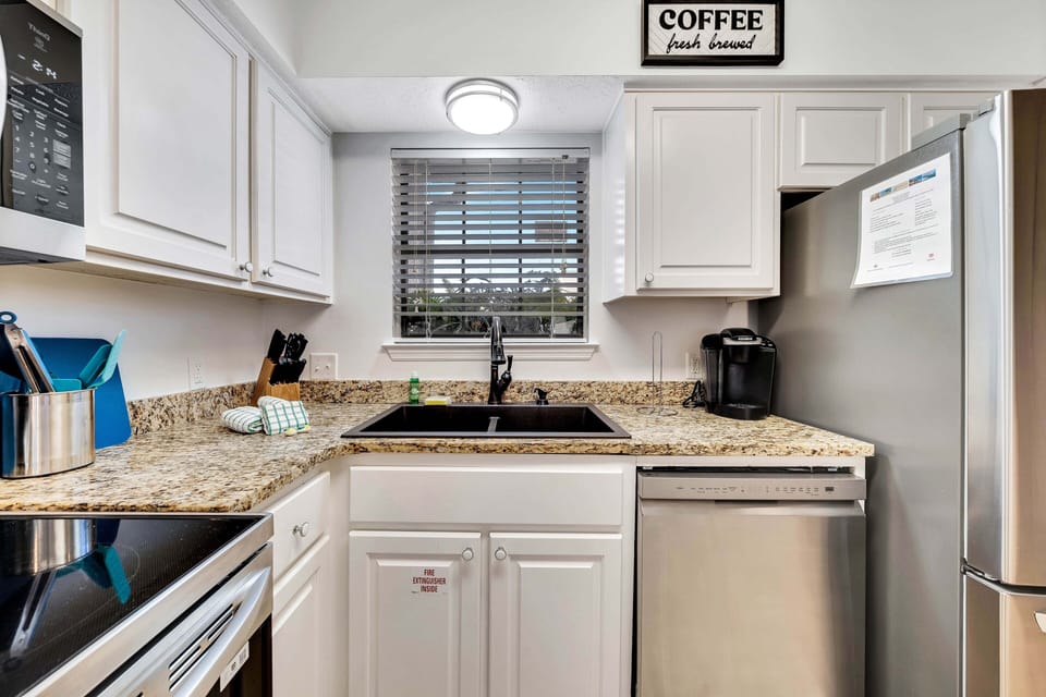 The fully equipped kitchen features granite countertops and BRAND NEW (2024) appliances and cookware.