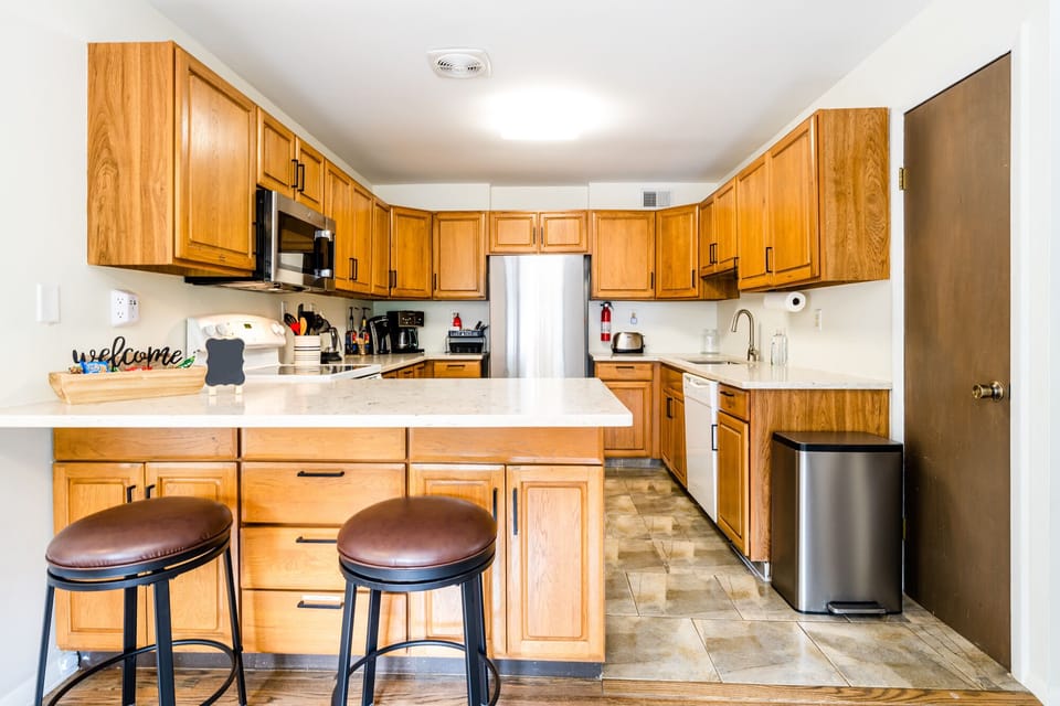 Fully stocked Kitchen on entry of unit with counter top seating