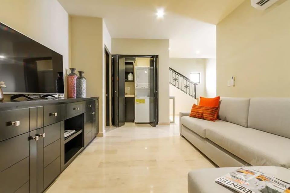 TV room and closet with washer and dryer. 