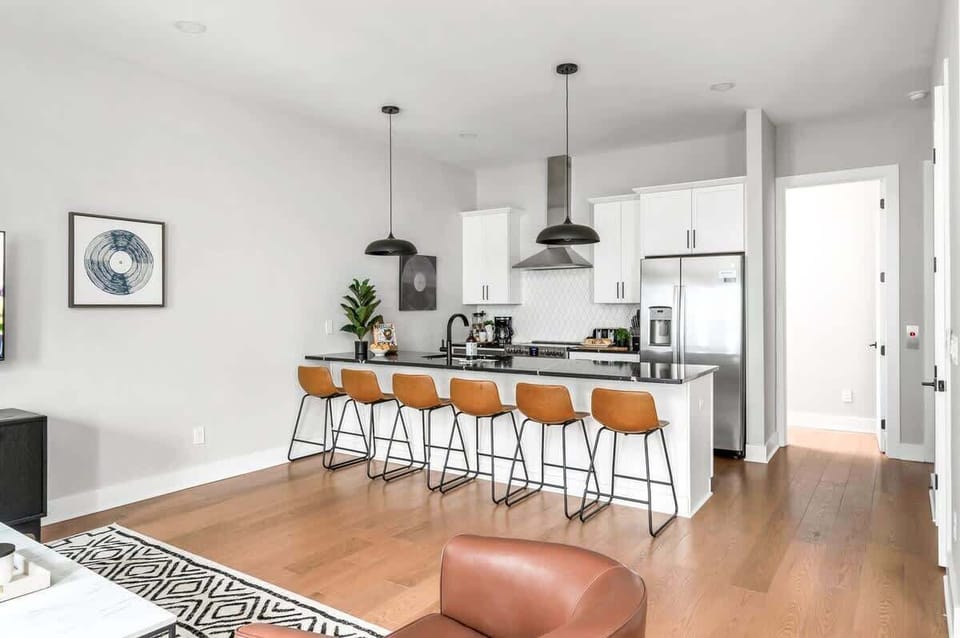 Functional and elegant kitchen with a six-seat island and stainless steel appliances.