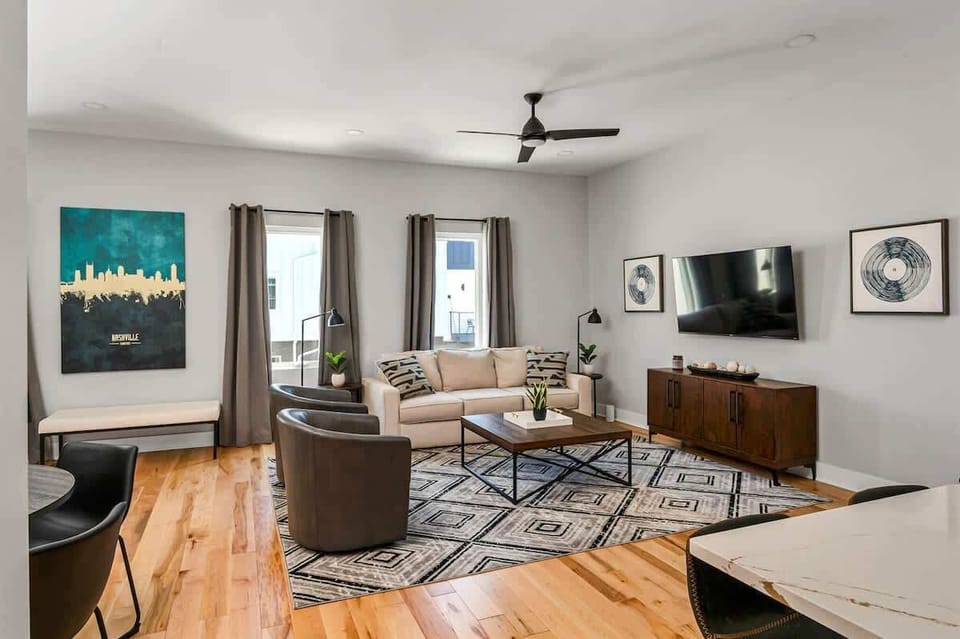 Spacious, light-filled lounge with stylish white and brown furnishings.