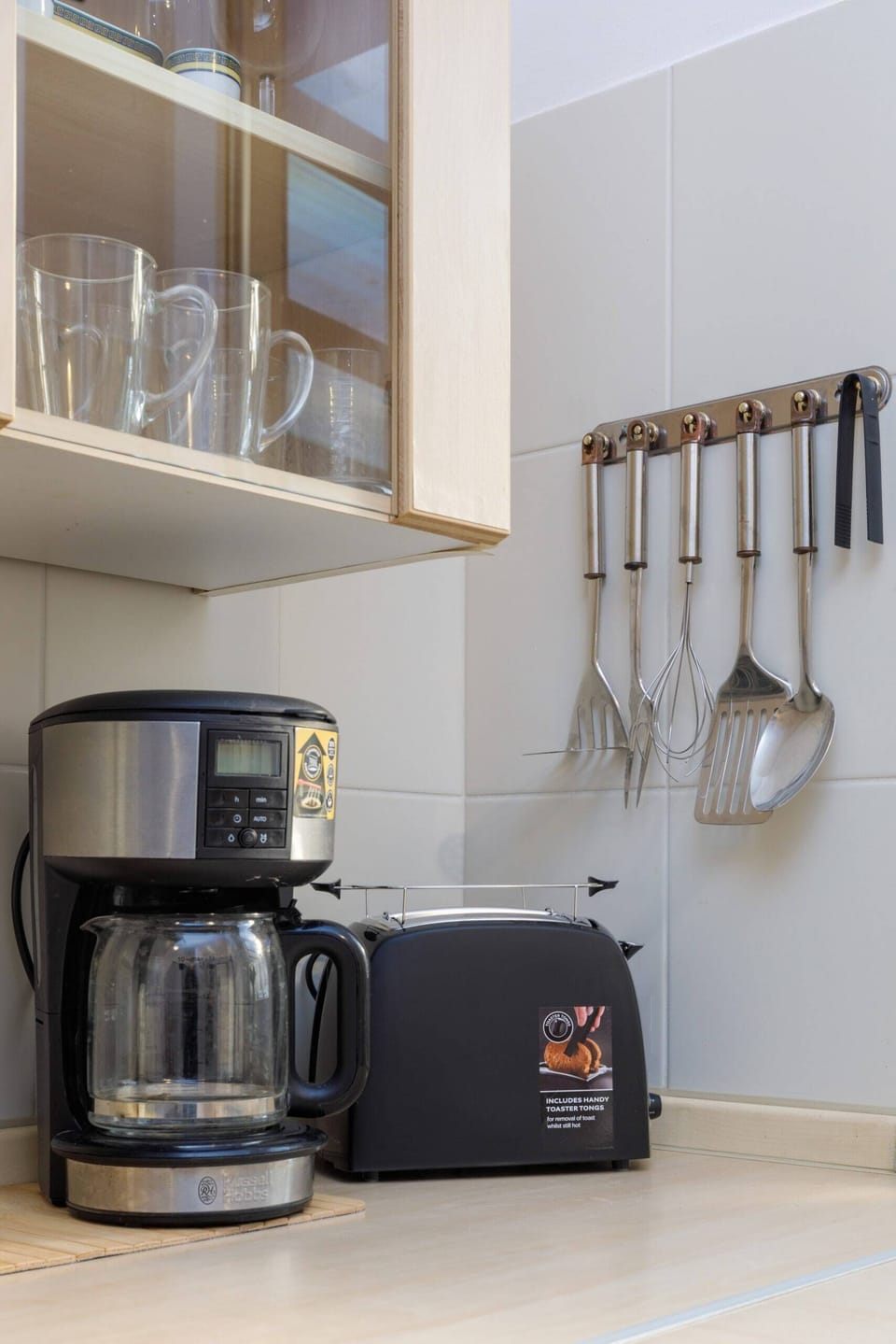A close-up of a coffee maker and kitchen utensils, ensuring convenience for guests.
