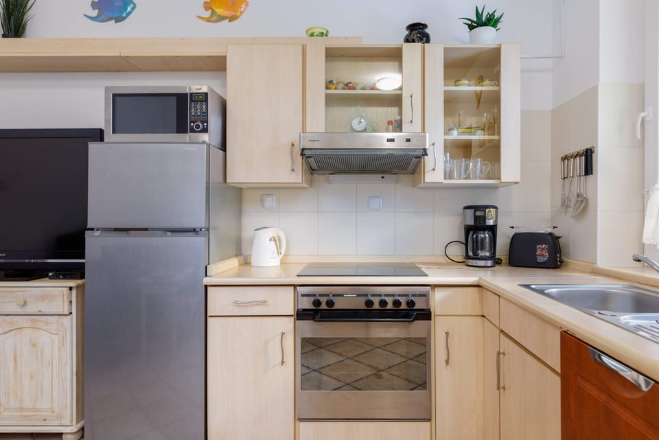 A wide-angle view of the kitchen, showcasing ample storage, a sink, and dining space nearby.
