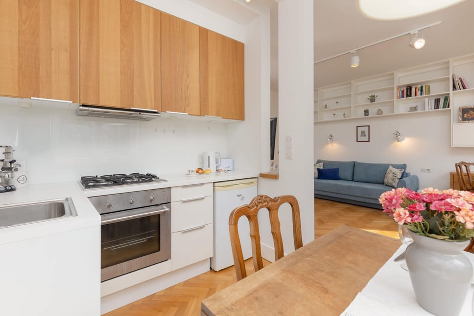 A functional kitchen with wooden cabinets, a gas stove, and a dining area for meals.
