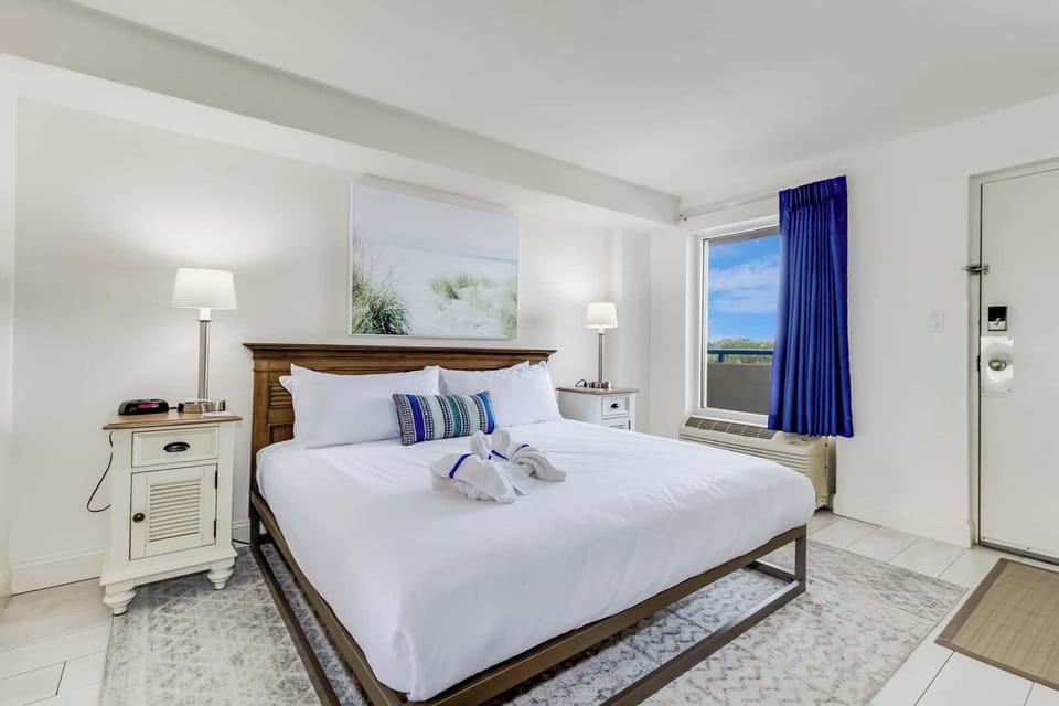 Drift off in a cloud of coastal calm—this king-size retreat is wrapped in crisp linens, beachy charm, and just the right amount of sunshine. Rest, recharge, and wake up steps from the shore.