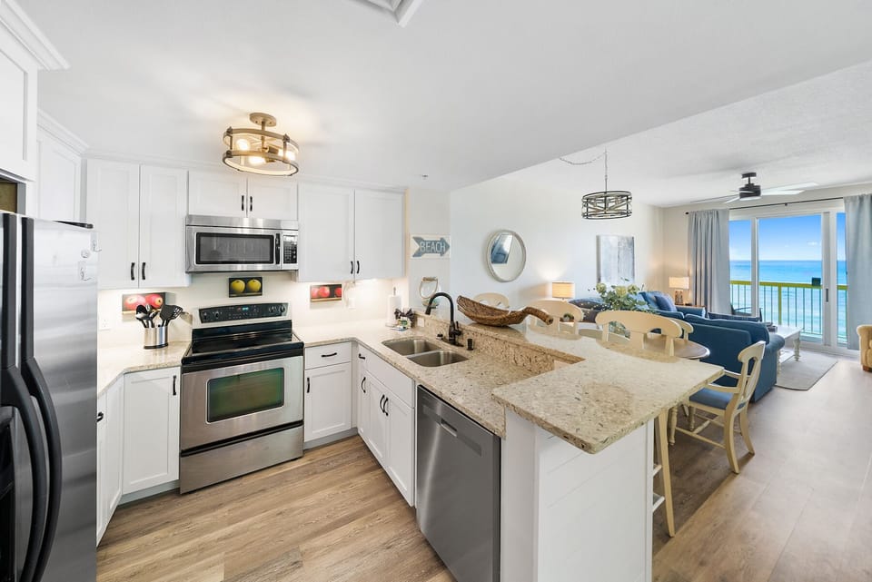 Your bright kitchen with granite counters flows into the living space, where ocean views await through floor-to-ceiling windows.