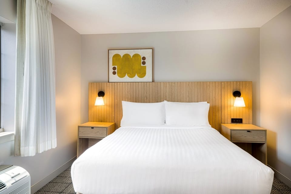Drift off fast in a plush bed with warm lighting.