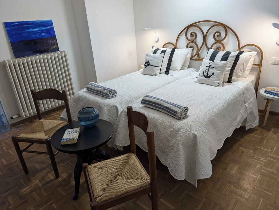 This room has parquet wood floors, 2 single beds and two bedside tables. 