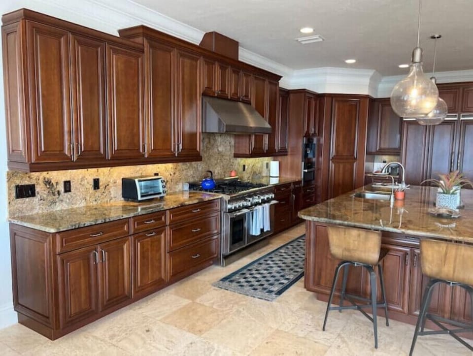 Extensive kitchen island seating six. Luxury kitchen appliances and bar area.