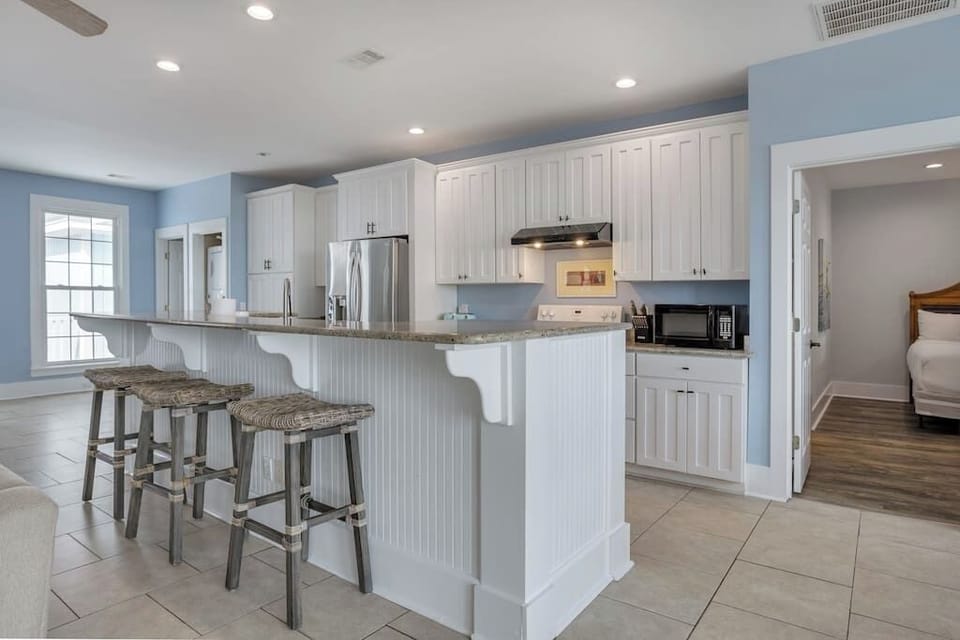 Kitchen with bar top. Three barstools. 